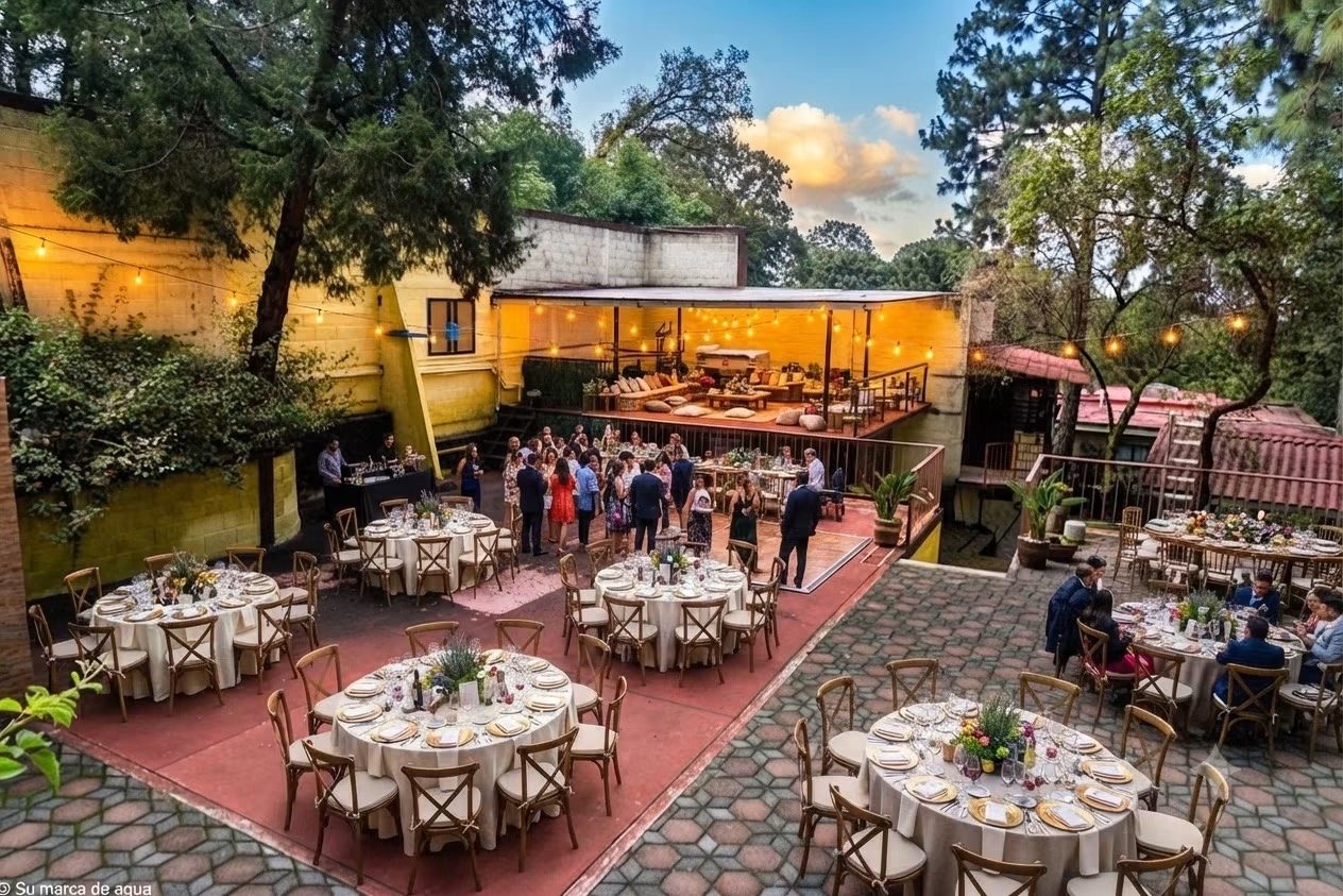 Montaje de evento al aire libre en Casa 63, rodeado de árboles